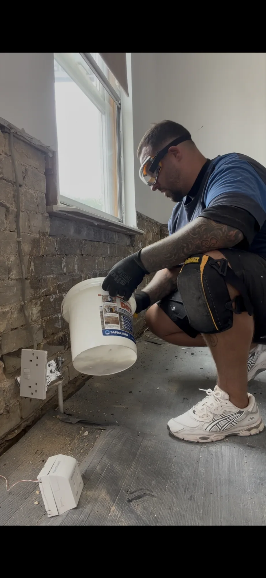 A replacement damp-proof course being installed at floor level in a solid wall
