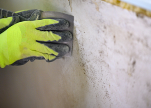 person wearing gloves sanding a wall to remove old paint or finish cleaning and maintenance tips for home improvement and repairs 5 sandpaper techniques